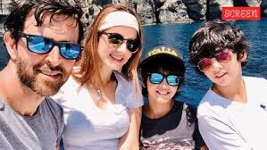 Hridaan Roshan standing next to his abstract artwork on display