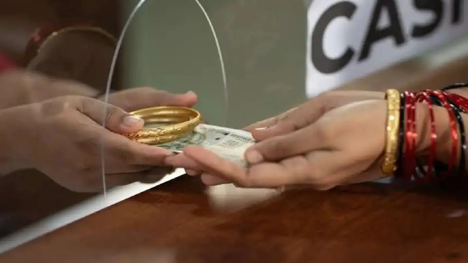 Gold jewellery being weighed and evaluated at a loan counter in India, symbolizing RBI’s new gold loan valuation norms