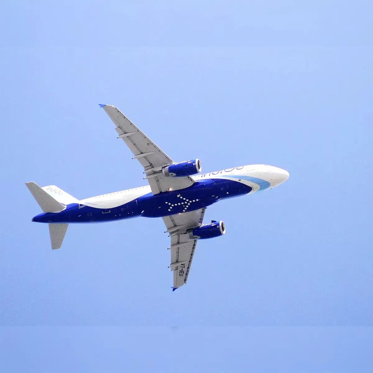 IndiGo aircraft at airport during monsoon with promotional fare banner showing ₹1,499 flight sale