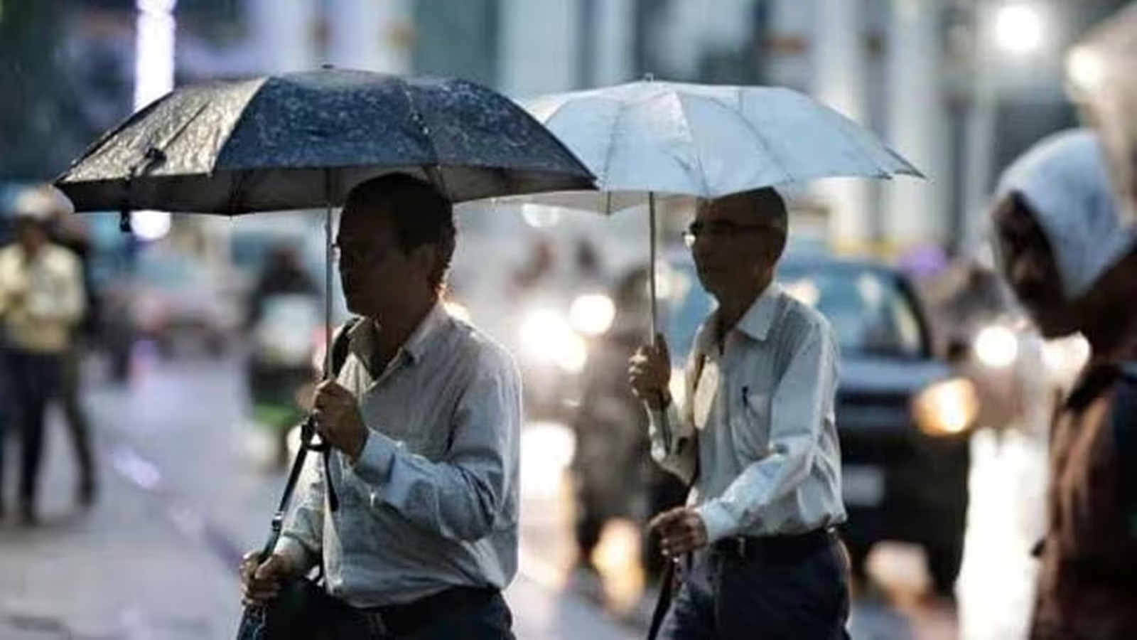 People walking with umbrellas as rain hits Chandigarh at the start of the monsoon.