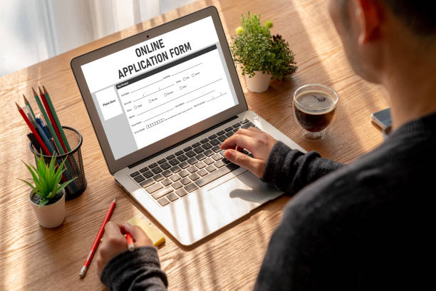 Students filling online exam form on laptop