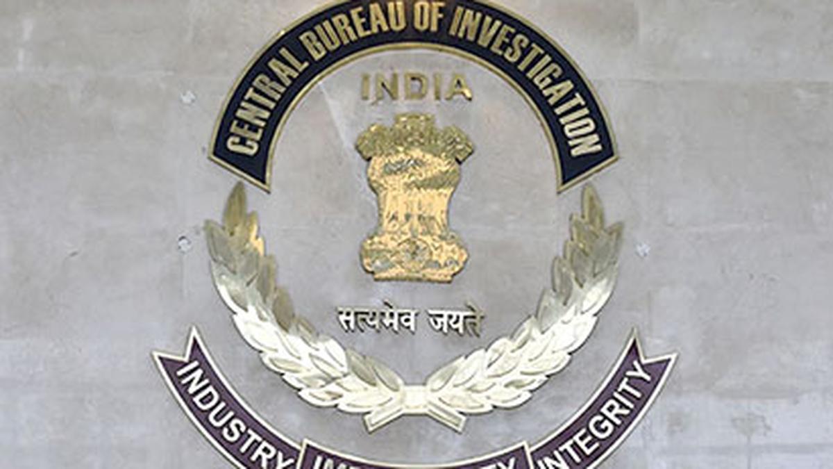CBI officials escorting an arrested individual involved in a 40-year-old bank fraud case
