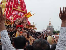 Devotees gather in Puri for Jagannath Rath Yatra 2025 with decorated chariots in background