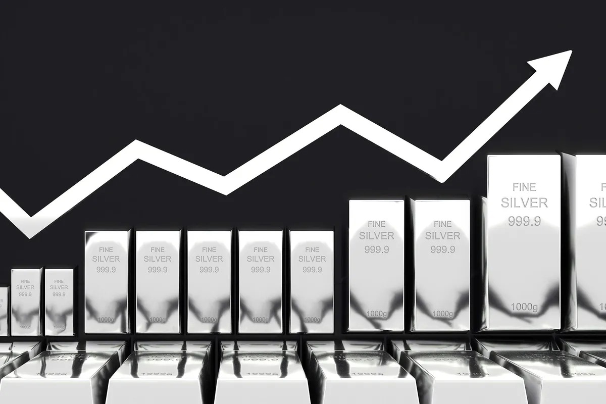 Silver bars and coins with upward financial graph showing price surge forecast for 202