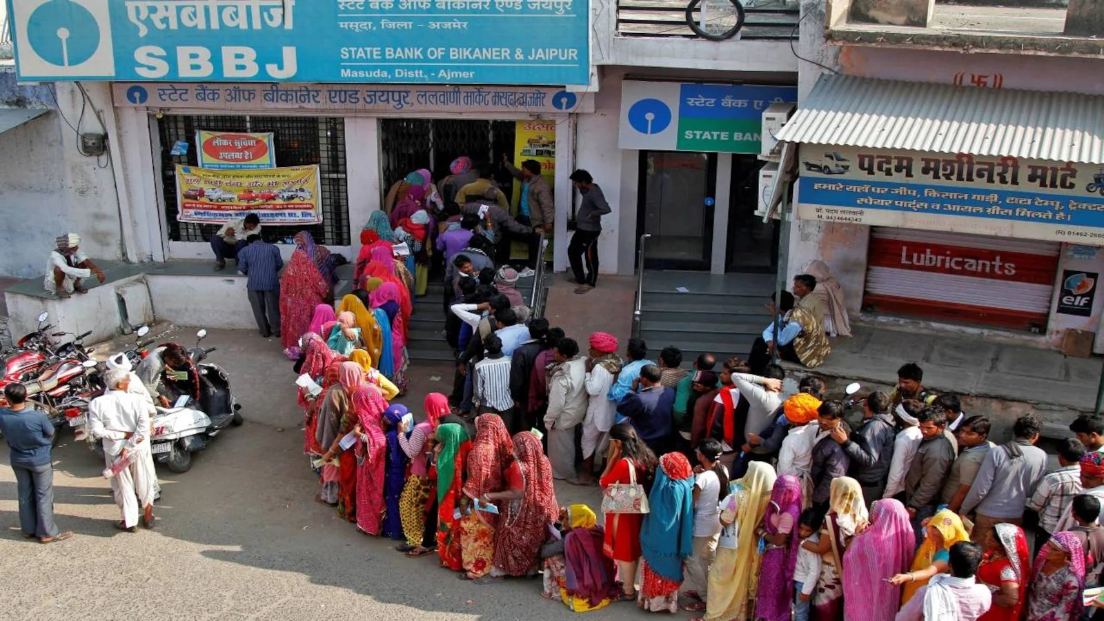 Customers queue outside an Indian bank on a regular working day in June.