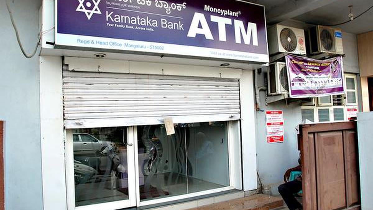 Karnataka Bank building with falling stock market graph overlay