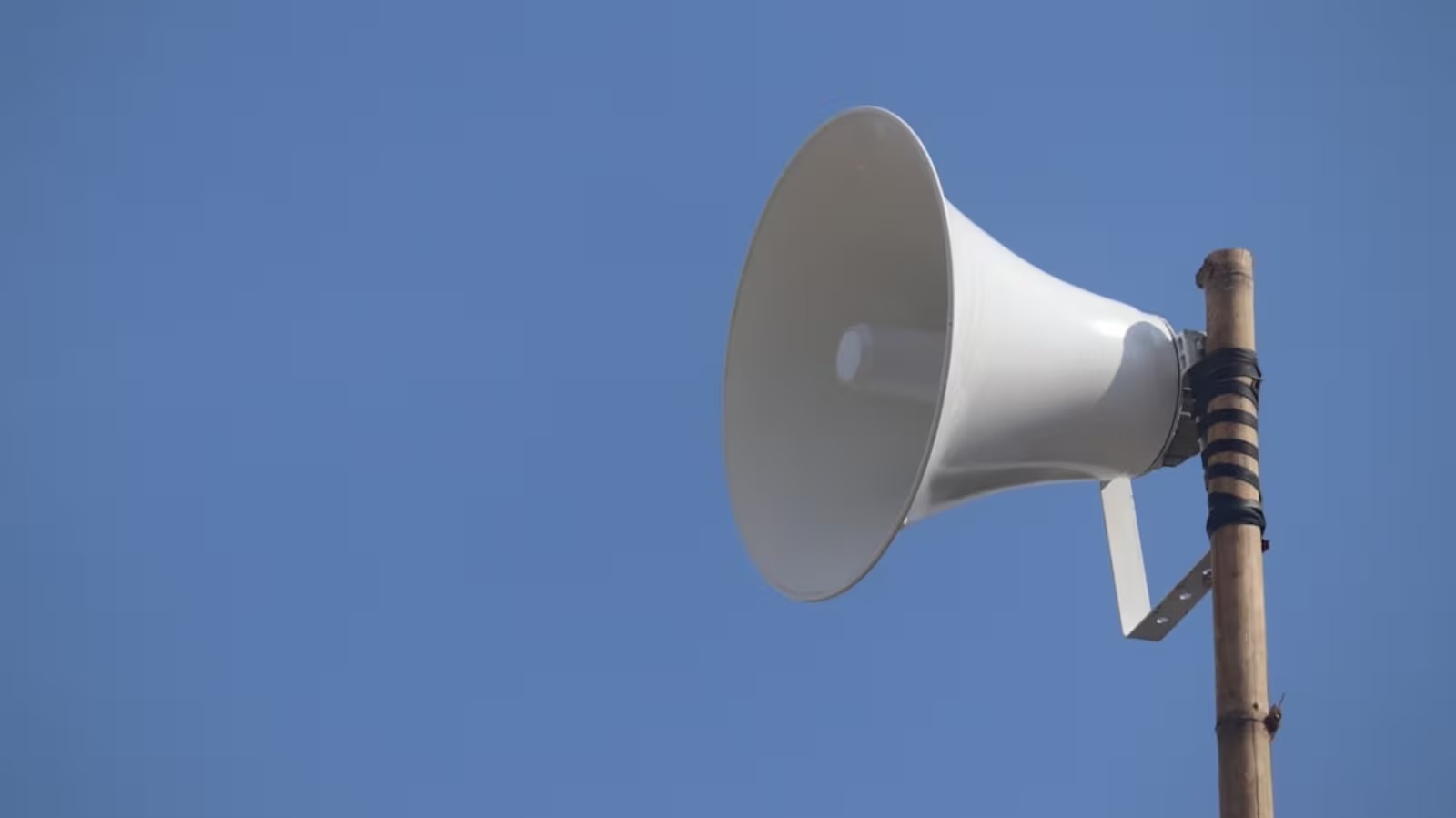 Police officers inspecting a loudspeaker setup at a public place in Mumbai