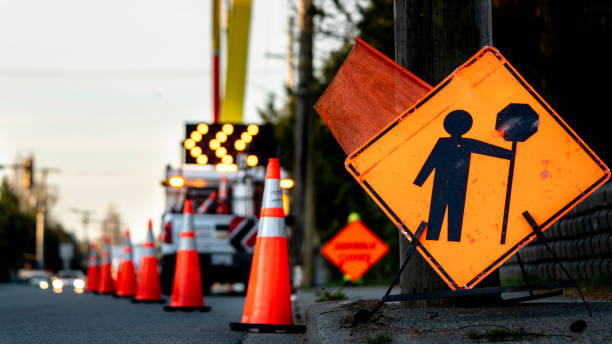  Road construction site with halted machinery and a sign indicating penalty on contractors