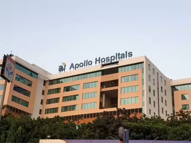 Apollo Hospitals building with a bullish stock chart overlay and investor growth highlights