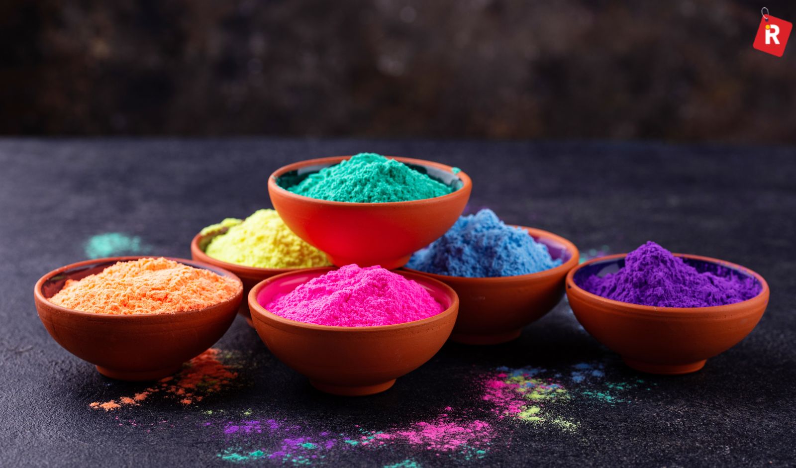 A Holi celebration with color powder, water balloons, and a family reviewing a budget chart on a Vizzve-branded phone.