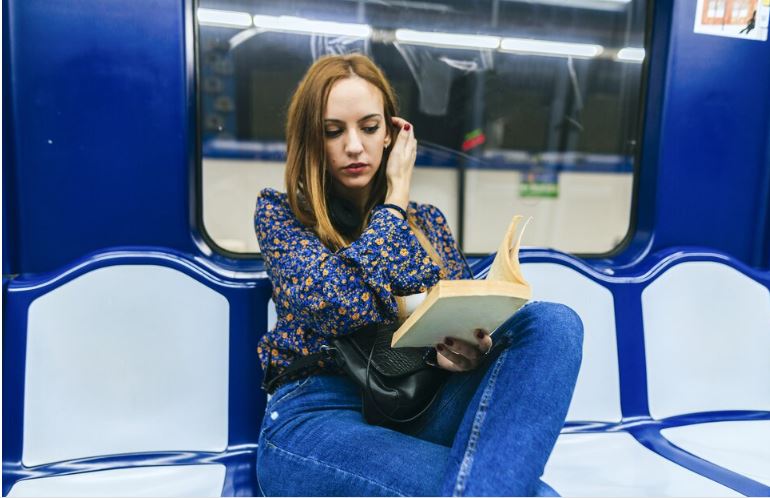 Stack of personal finance books for women on a wooden desk