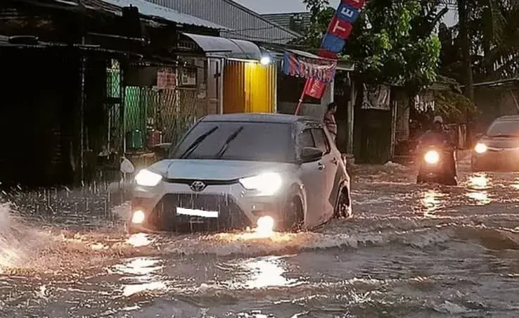 Car stuck in floodwaters with a cracked wallet floating nearby, symbolizing money loss during urban flooding.