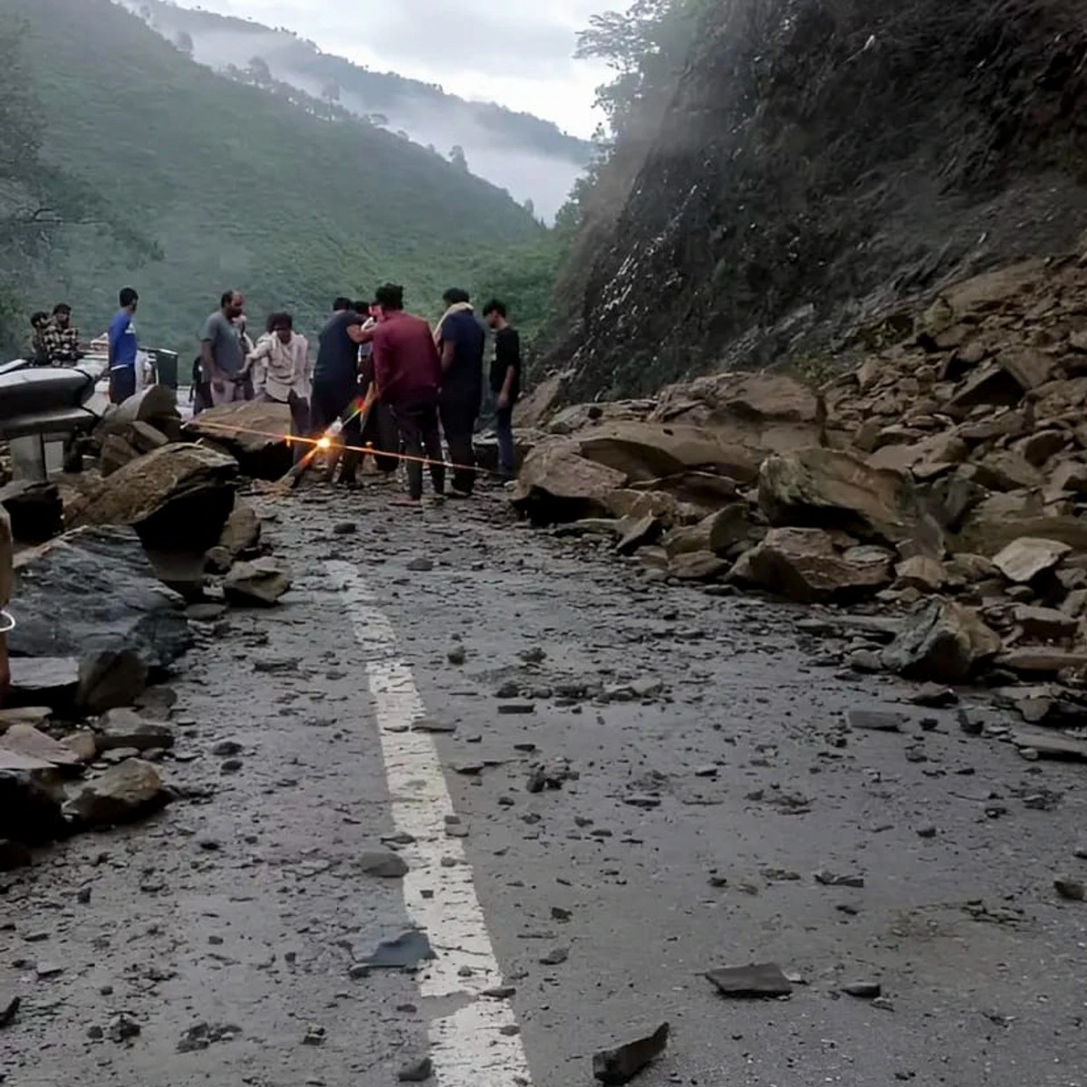 Landslide-prone zone in Uttarakhand under cloudy sky with warning signs