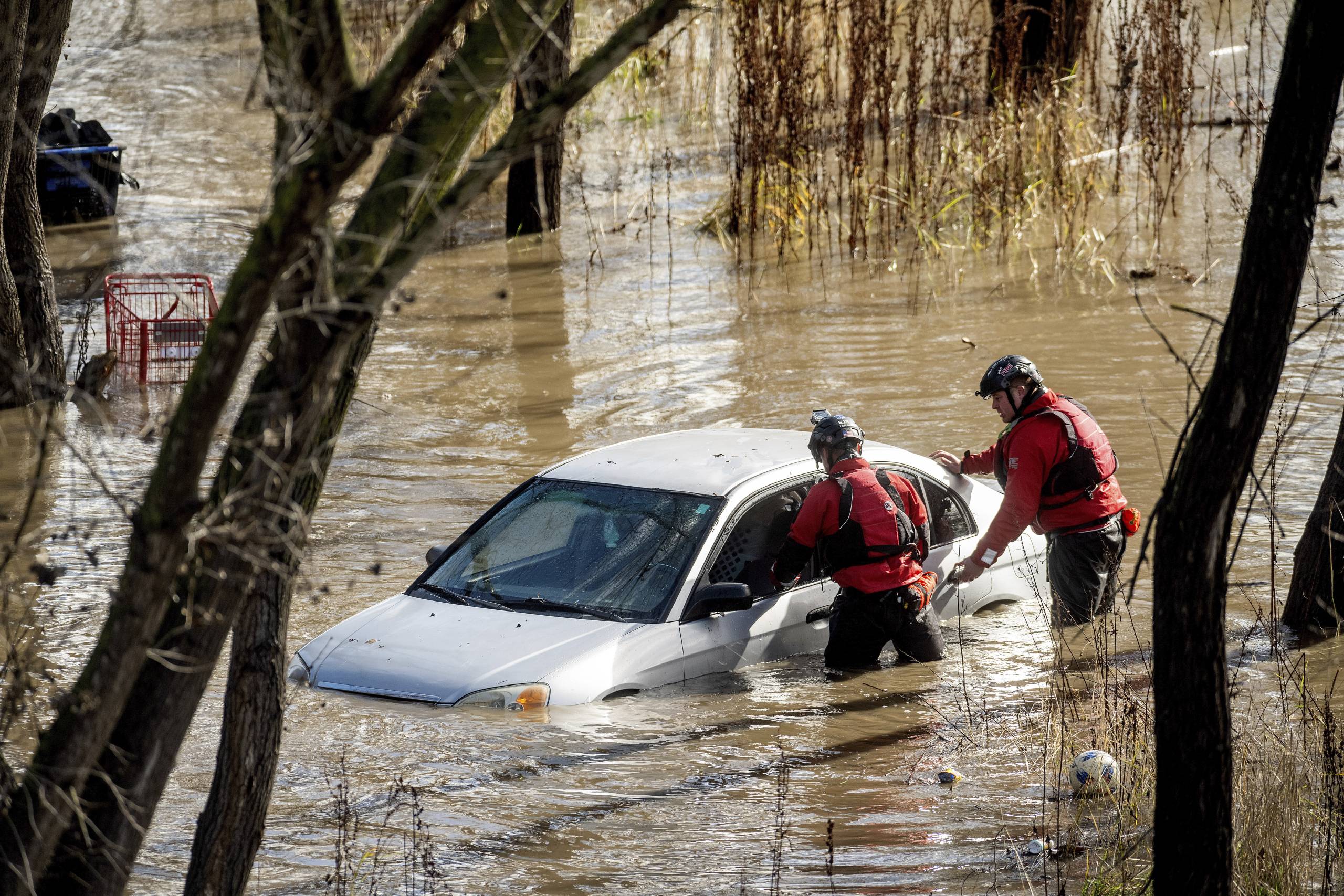 Renter wading through flooded apartment with damaged belongings