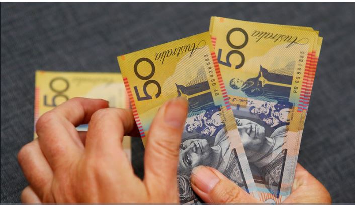 "Currency trader monitoring Asia FX and AUD/USD charts amid tariff and RBA news"