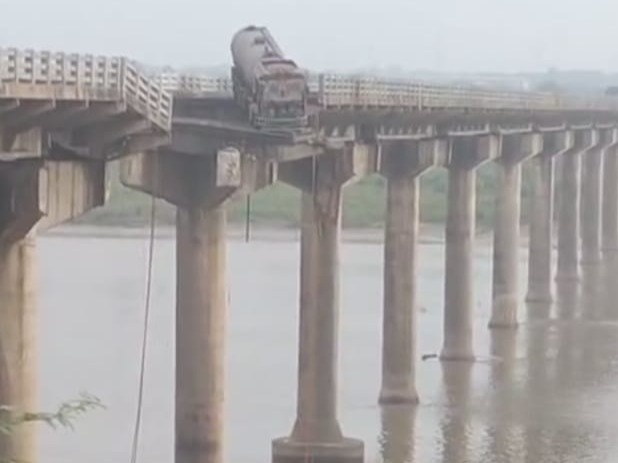Broken bridge in Gujarat with vehicles submerged in river