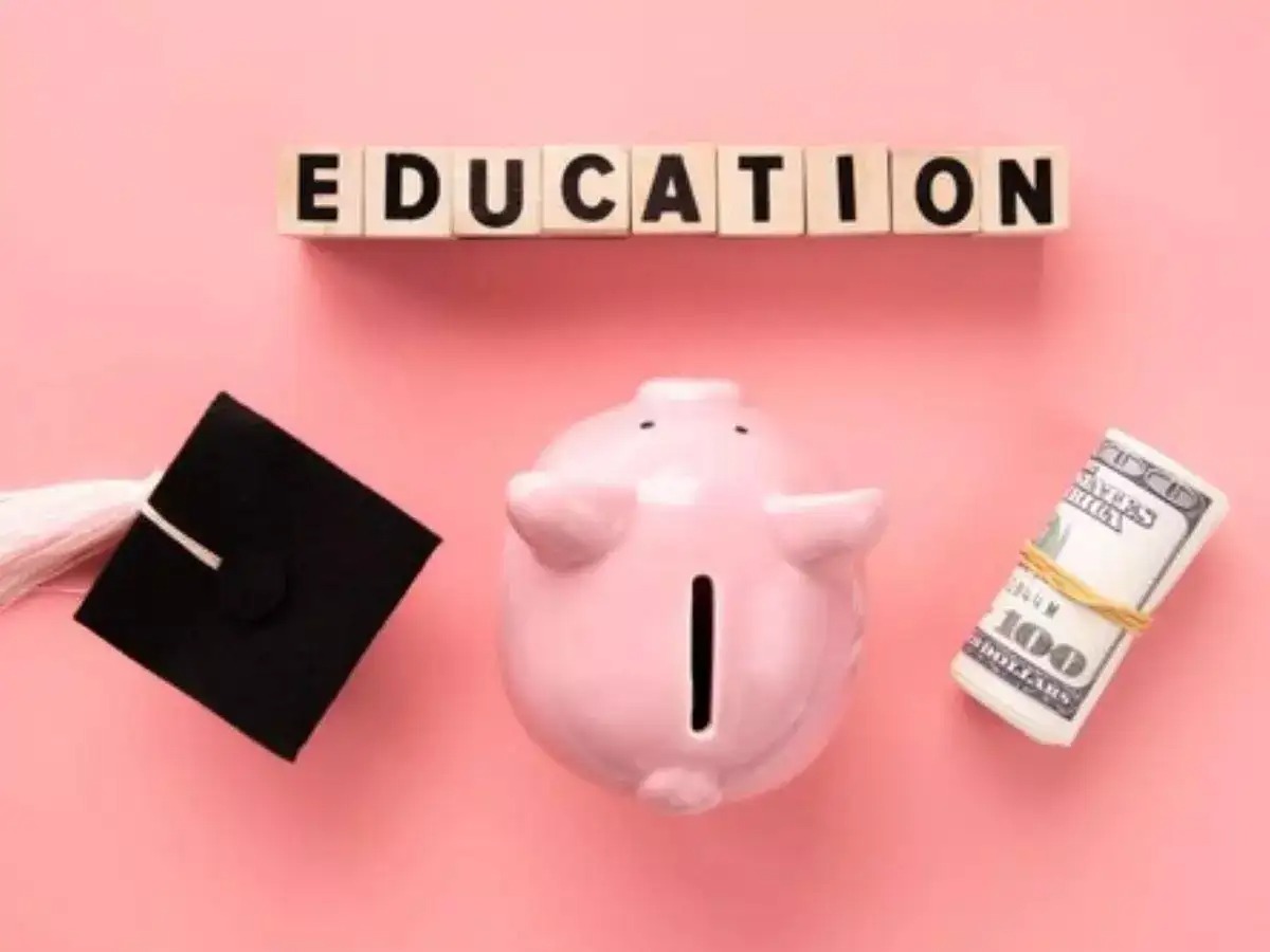 An Indian student looking at college brochures and a laptop with education charts, while a savings jar labeled “College Fund” sits beside.