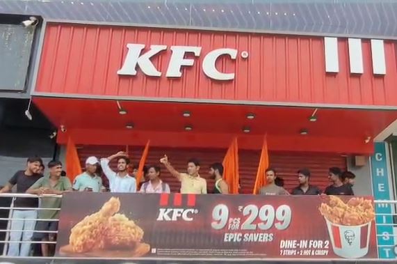 A closed fast-food outlet in Ghaziabad with a Sawan religious banner and protest in front.