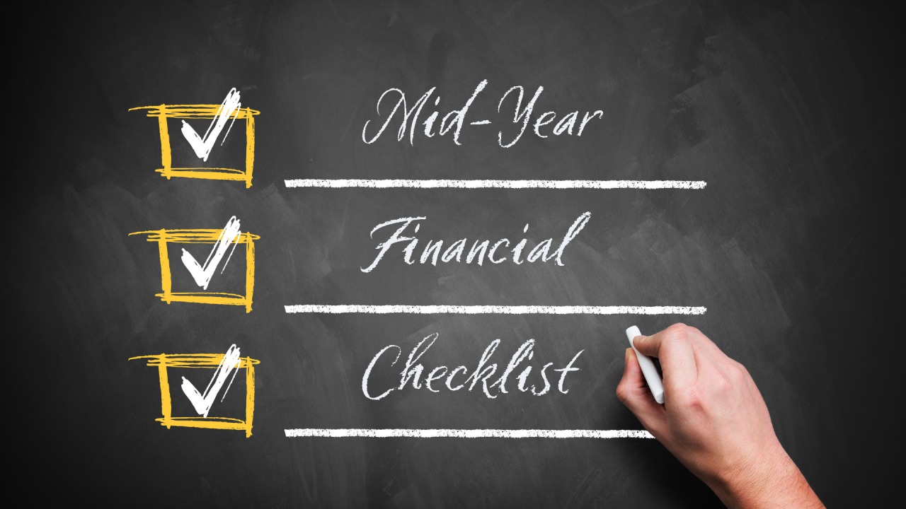 Mid-year financial checklist with planner, calculator, and money notes