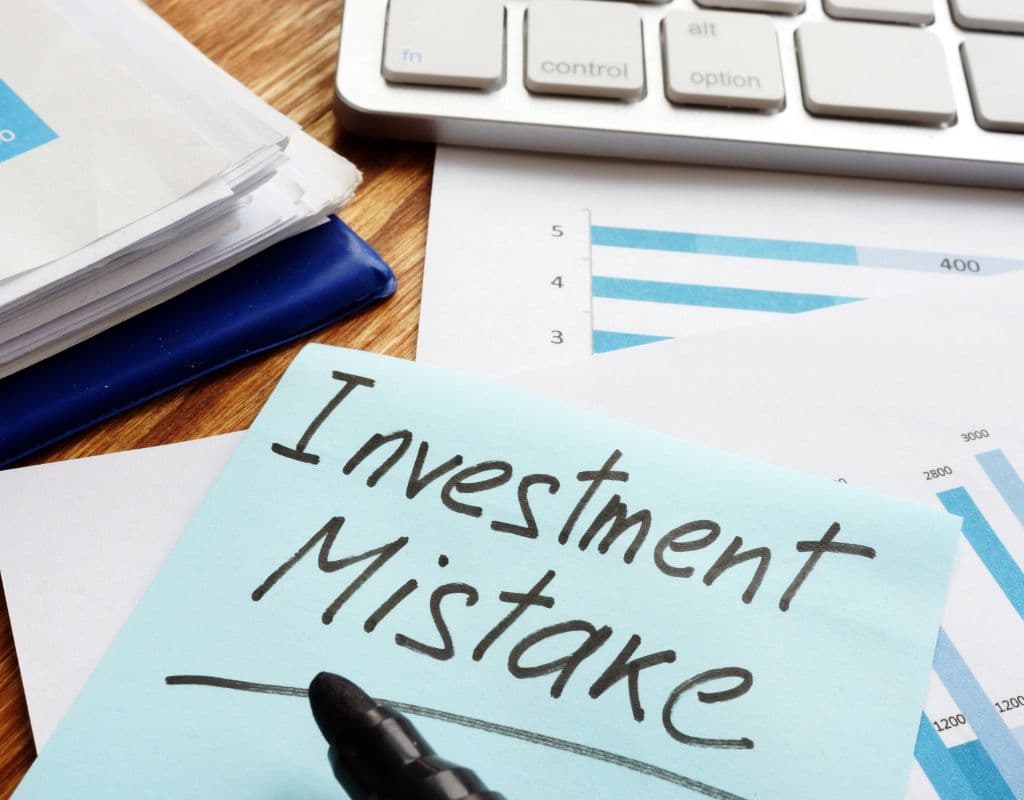 Investor checking phone with regret after making investing mistakes in 2025