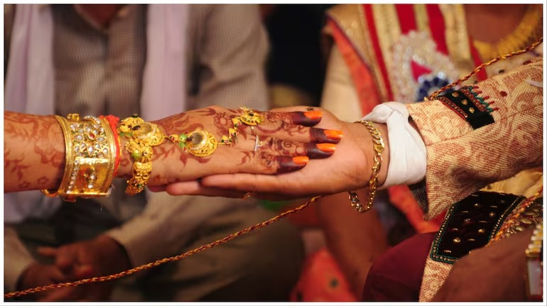 A happy couple checking their wedding loan approval on a smartphone with Vizzve branding in the background.