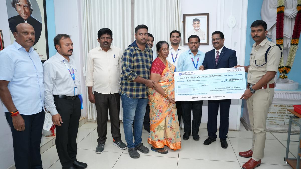 SBI officials handing over ₹1 crore insurance cheque to family of deceased ASI