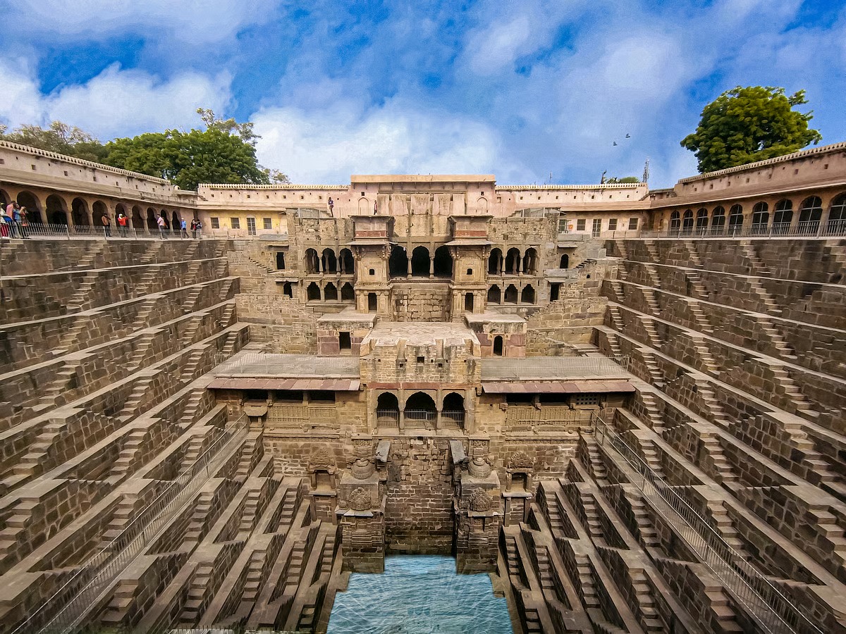 Intricate stone-carved stepwell with symmetrical stairs and pillars