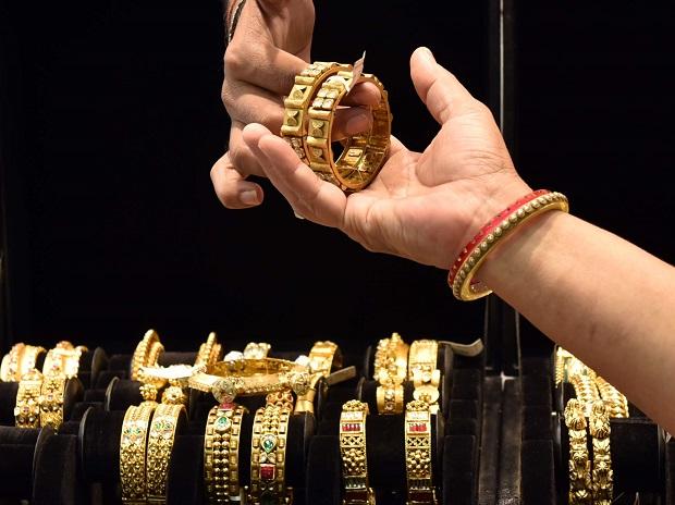 Indian family holding gold jewelry and comparing mutual fund options