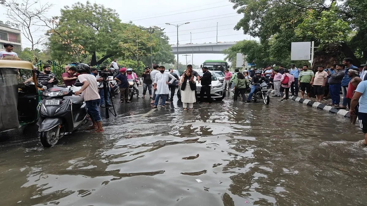 Delhi streets submerged during monsoon floods with stranded vehicles and pedestrians