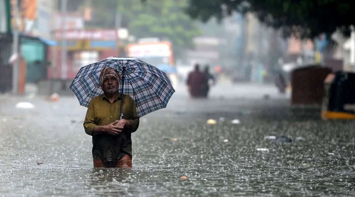 Heavy rain in a Tamil Nadu town during August, with umbrellas and flooded streets