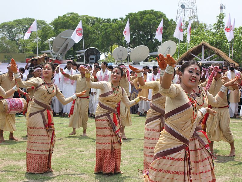 Assamese women performing Bihu dance in traditional attire during festival