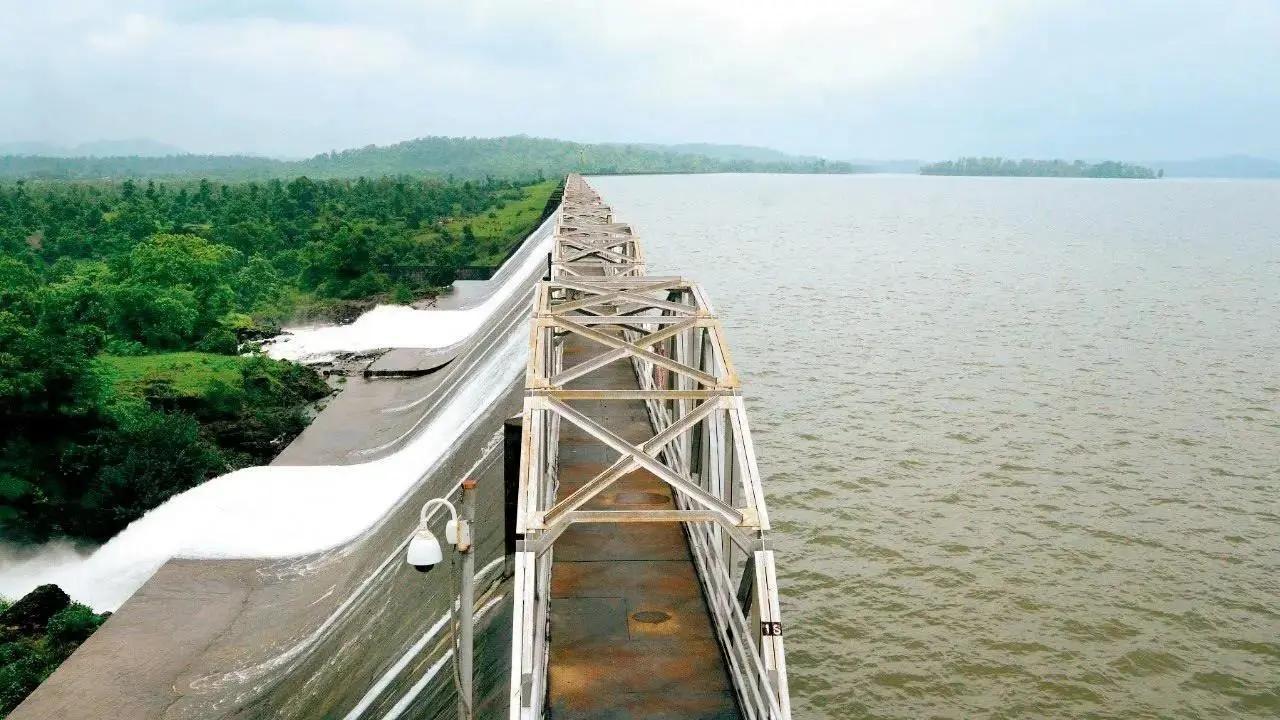 Full water reservoir near Mumbai with cloudy sky and incoming rain
