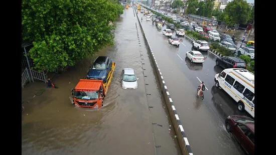 Flooded streets of Gurgaon with vehicles stuck and people wading through water