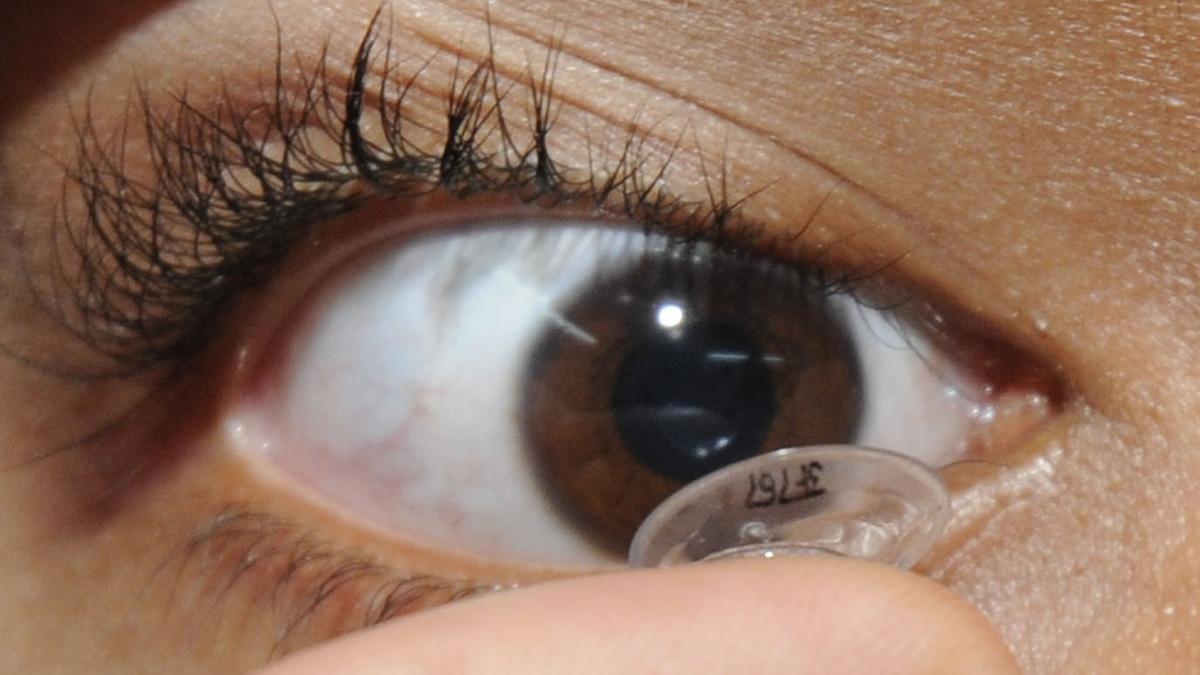 Close-up photo of a person inserting a daily disposable contact lens for modern eye care