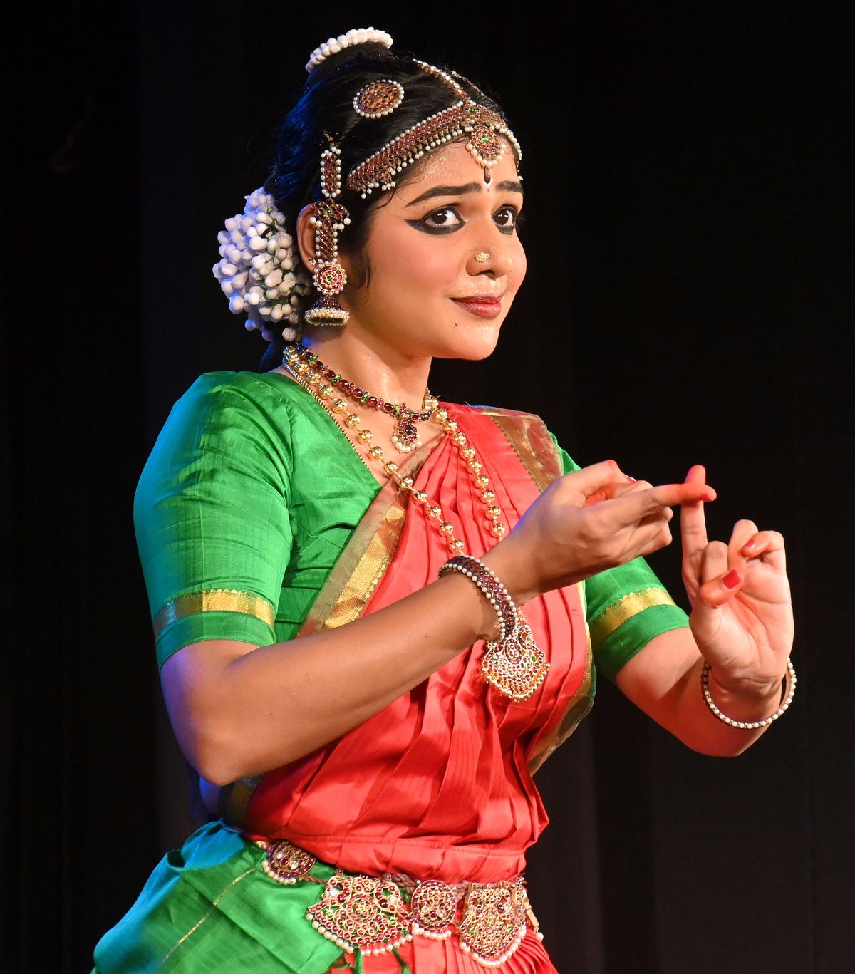 Young Bharatanatyam dancer Shruthipriya Vignesh performing with expressive abhinaya on stage, radiating poise and emotion