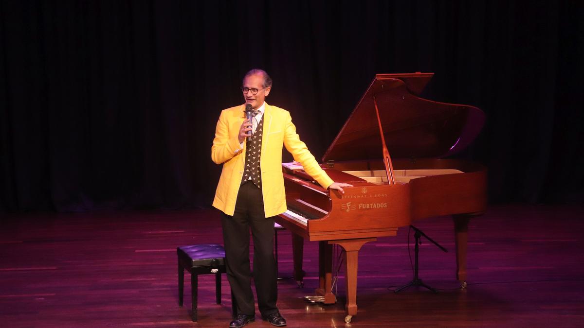 Karl Lutchmayer performing on a grand piano, visibly expressing a wide range of emotions through his playing, with a concert hall ambiance