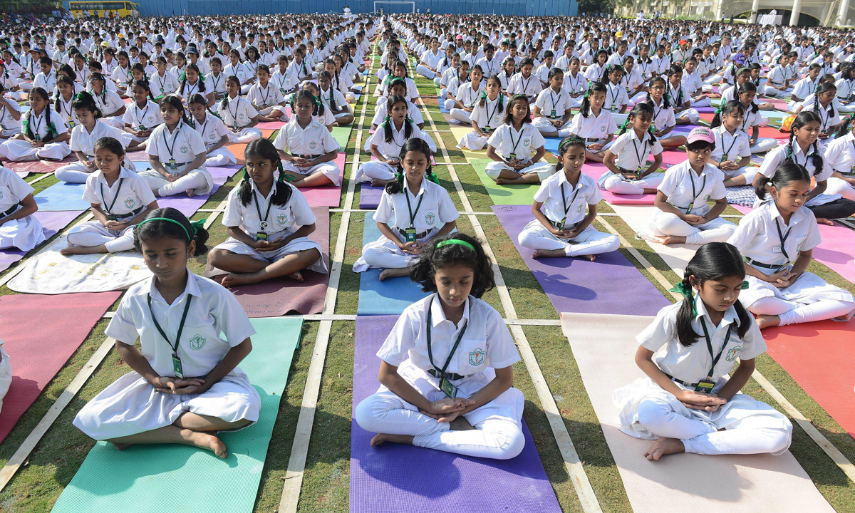 Children practicing yoga poses in a school classroom