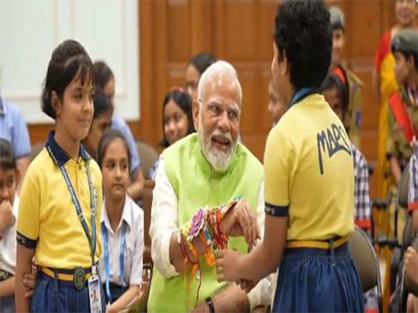 Schoolgirls tying rakhi on Prime Minister Narendra Modi’s wrist during Raksha Bandhan 2025 celebrations at his residence