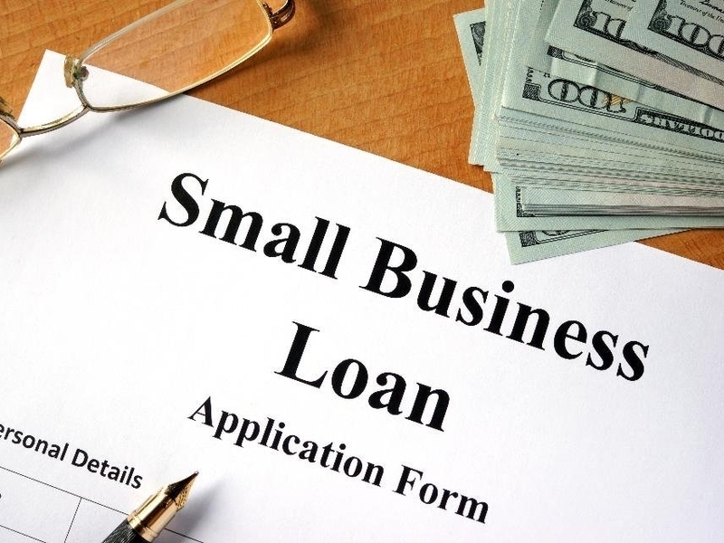 Entrepreneur planning a small business with loan documents, Vizzve Finance branding