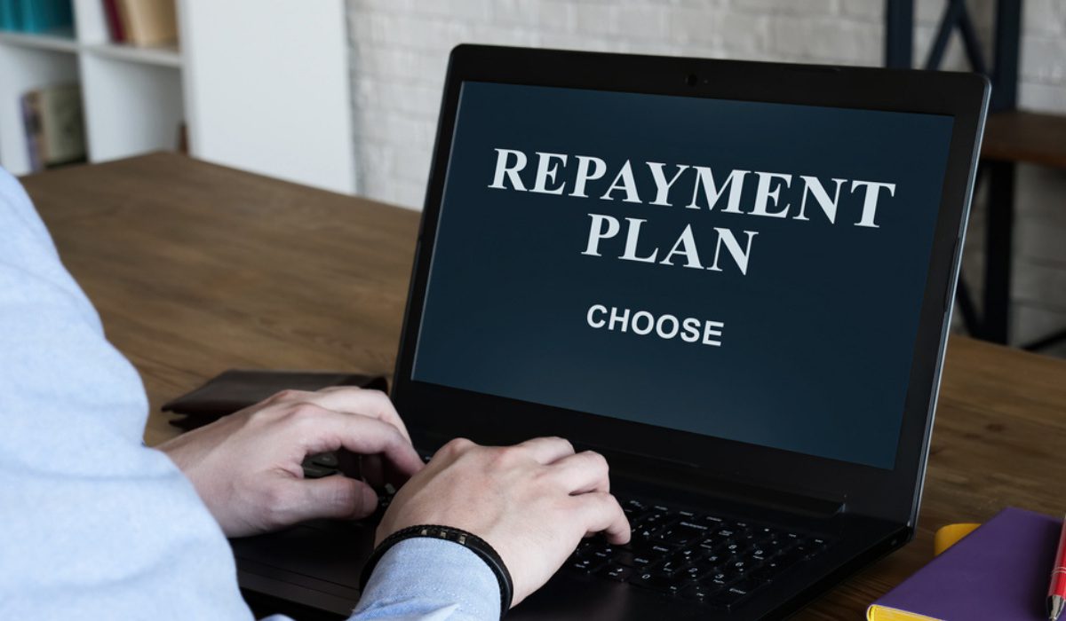 Person calculating loan repayments with flexible options, Vizzve Finance branding