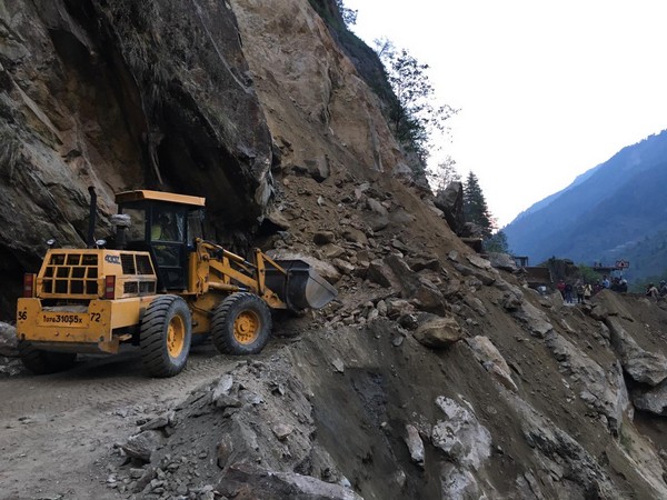 Bulldozer clearing debris after Netala landslide on Uttarkashi–Gangnani road