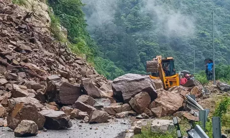 Landslide blocking Uttarkashi-Gangnani mountain road with rescue workers and machinery at work.