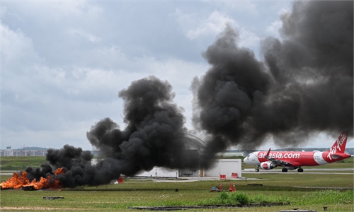 Thick smoke rising after a plane crash into a parked aircraft at a US airport tarmac.