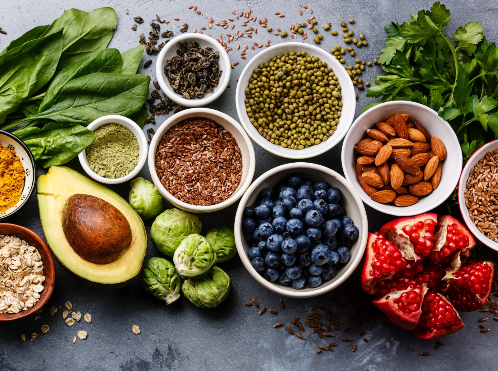 Assortment of superfoods including berries, leafy greens, nuts, seeds, whole grains, and spices for daily meals
