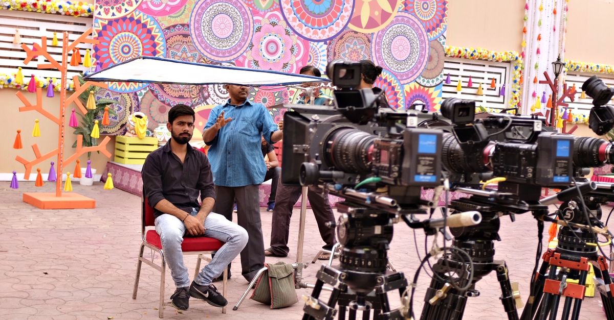 Behind-the-scenes of a big Bollywood film showing actors, director, and crew on set