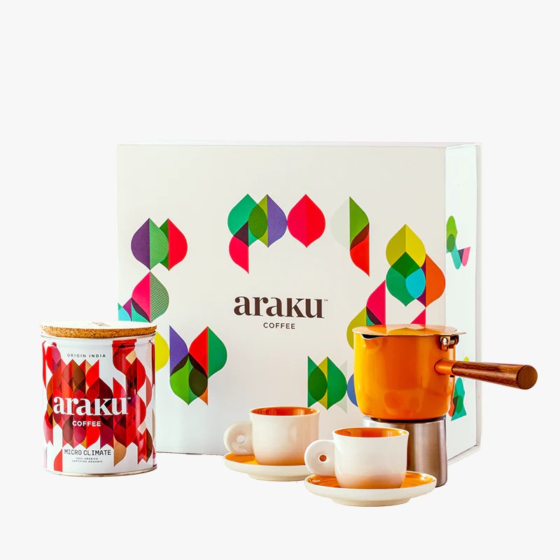 Freshly brewed Araku coffee served in a cup with coffee beans around