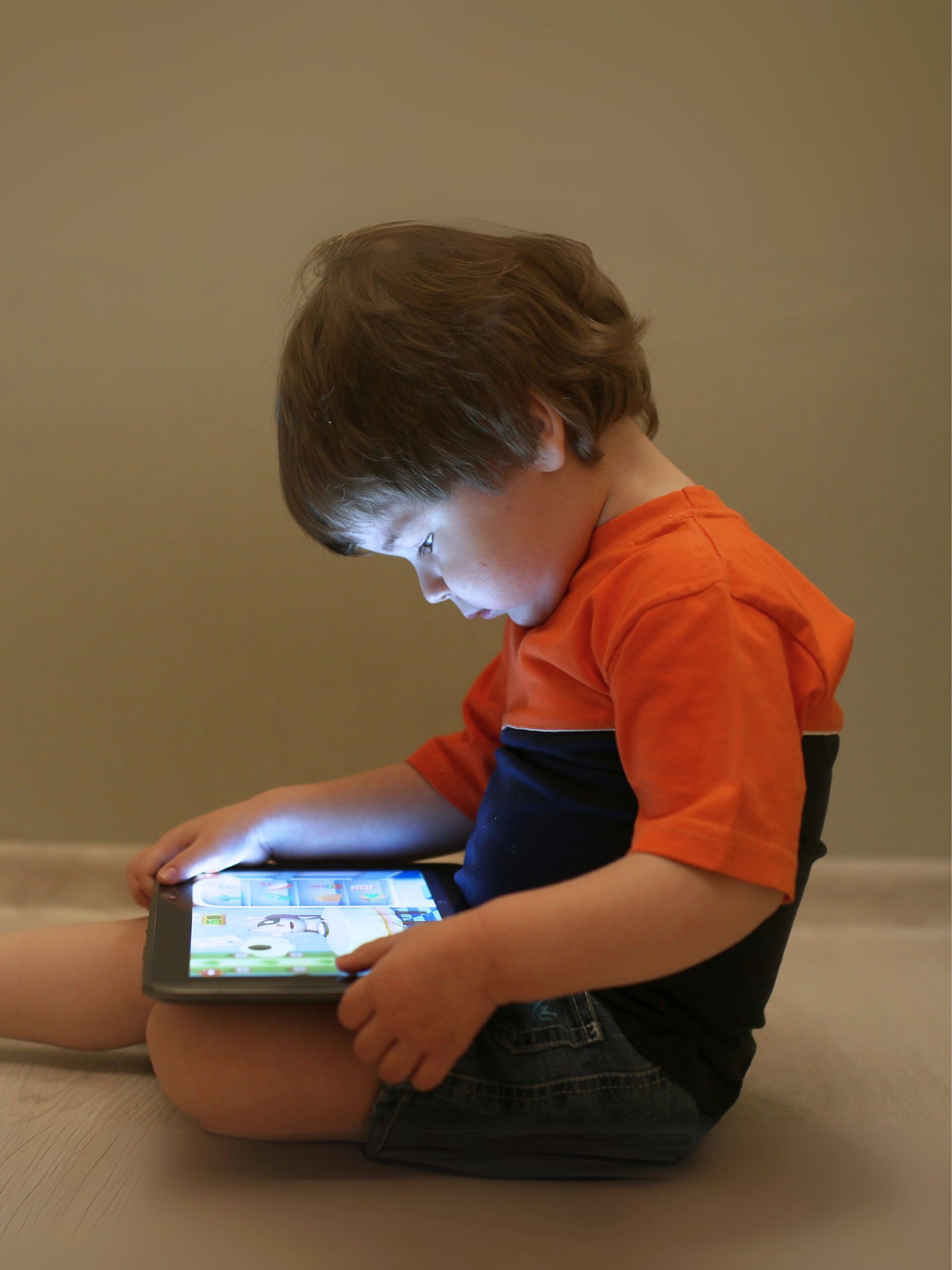 Child using tablet with potential heart health risks due to excess screen time
