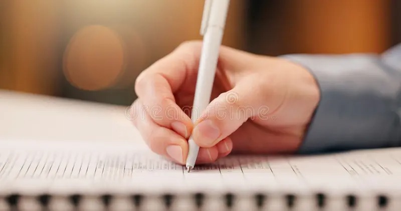 Person signing loan insurance documents at bank
