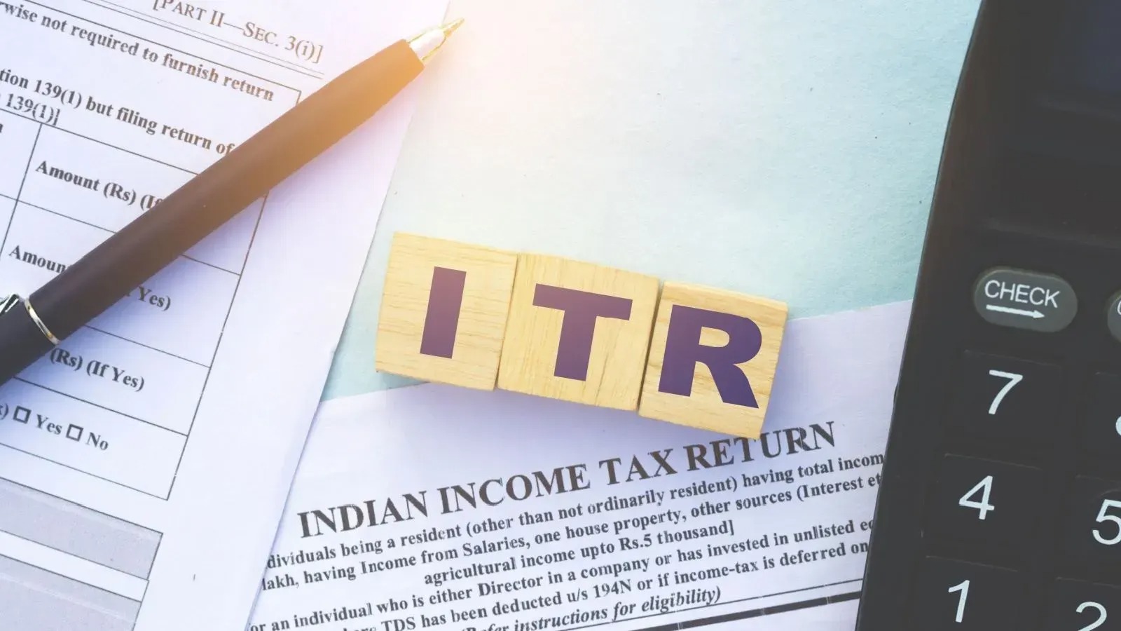 Taxpayer filing ITR 2025 online with investment documents on desk