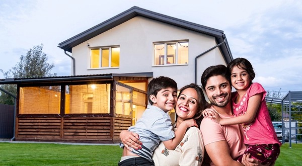 Happy family in front of their new home with housing loan subsidy benefits.